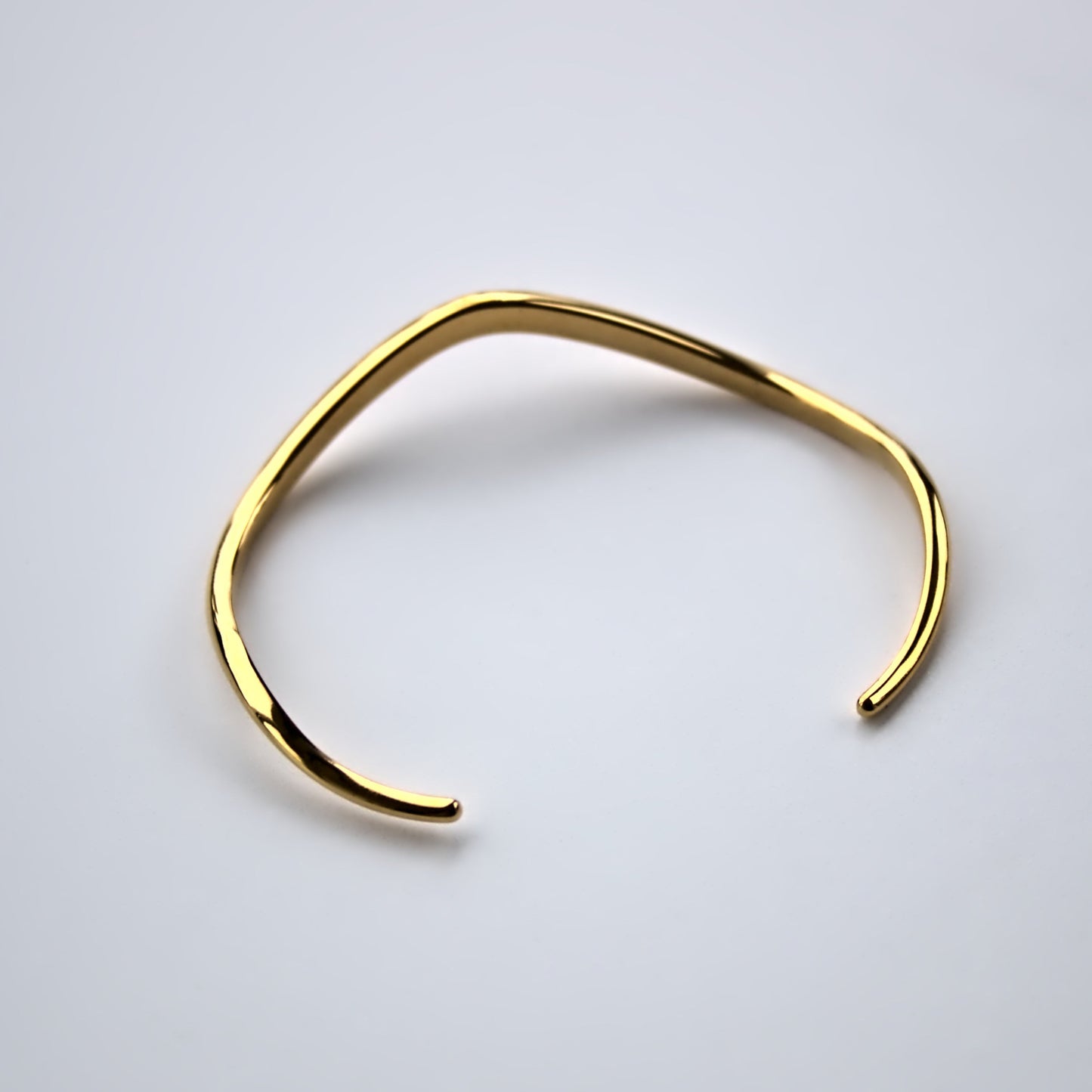 back profile of V shaped cuff bangle on white surface.
