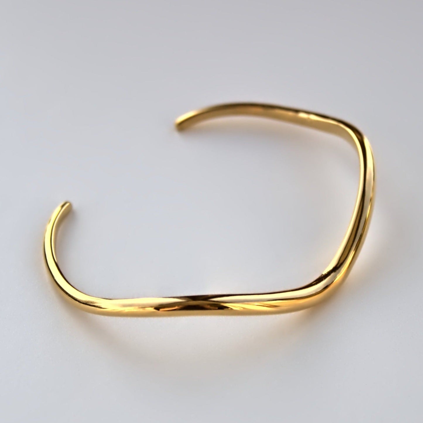 Top profile of V shaped cuff bangle on white surface.