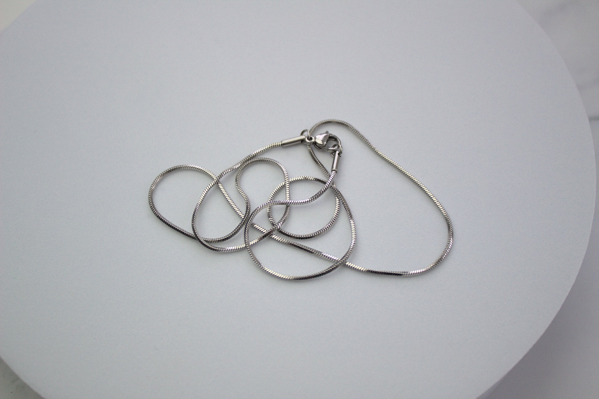 1mm snake chain on surface.